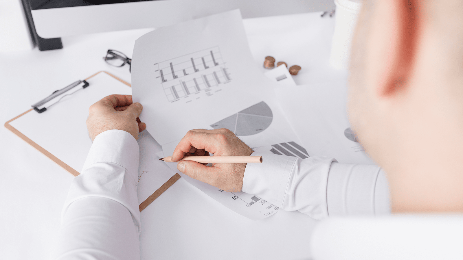 Маркетолог изучает отчёты с графиками, фиксируя выводы для анализа конкурентов сайта