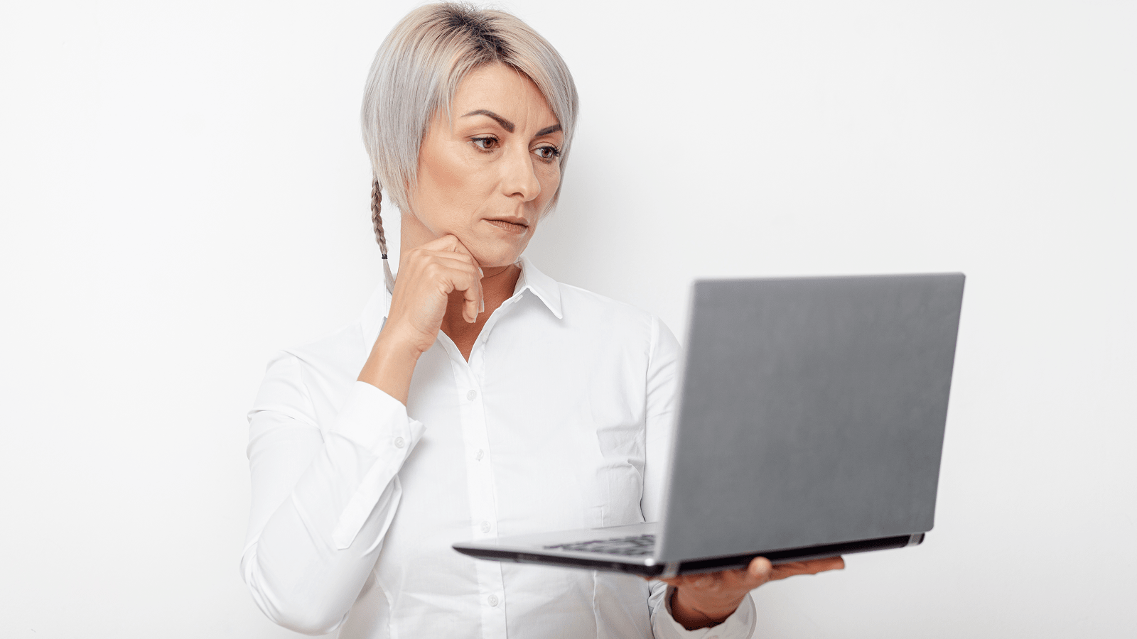 Женщина в белой рубашке изучает сайт на ноутбуке