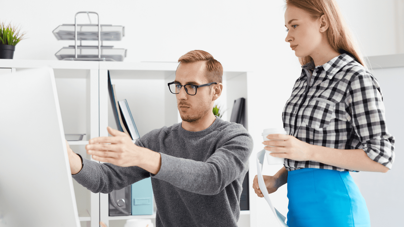 Обсуждение требований к сайту: мужчина у компьютера, коллега с документами