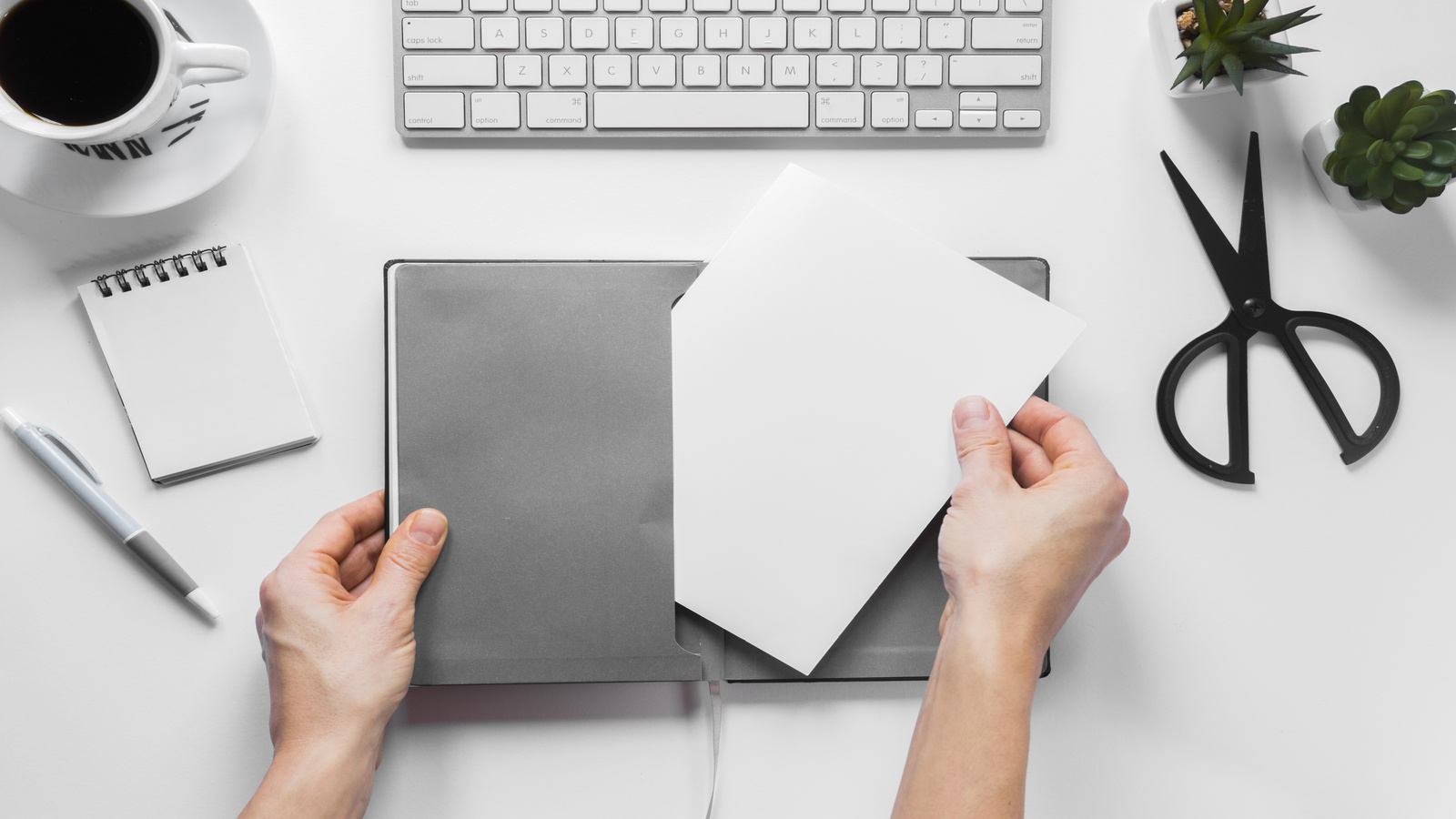 Руки держат блокнот и лист для контент-брифа на рабочем столе