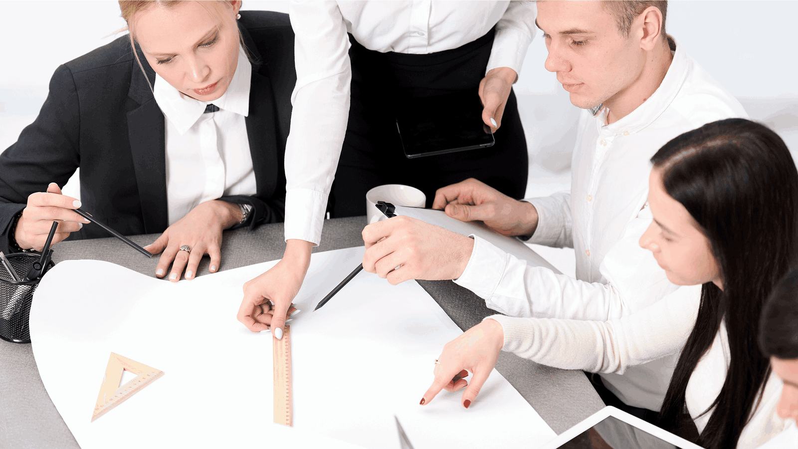 Команда дизайнеров совместно обсуждает проект, работая с макетом за столом