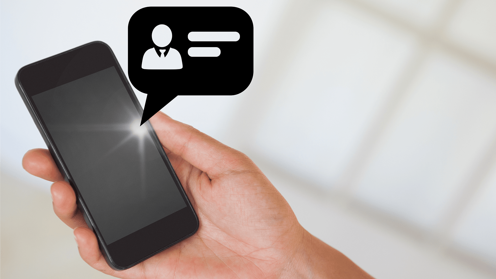 Рука держит смартфон с иконкой уведомления в пузыре