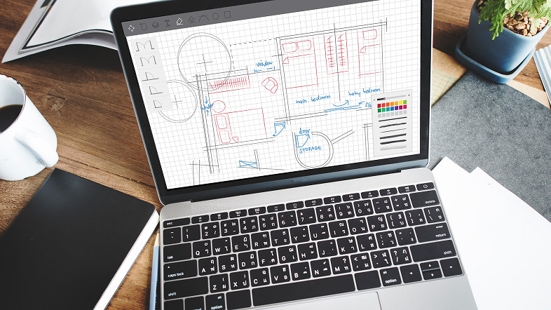 Ноутбук с планом на столе рядом с чашкой