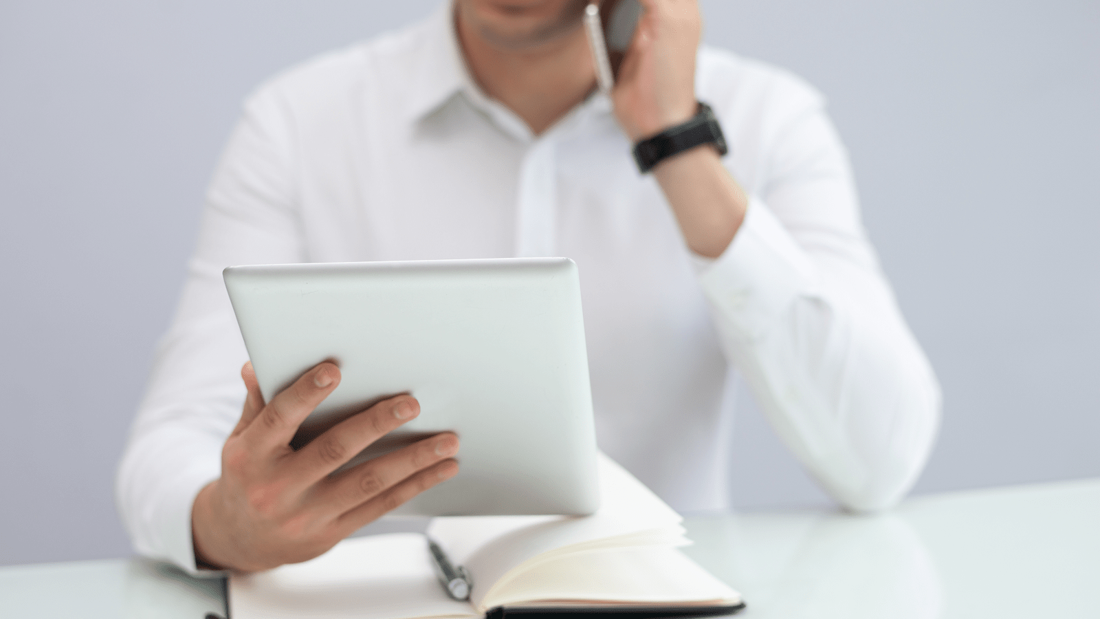 Проведение пользовательского интервью: специалист с планшетом и телефоном за столом