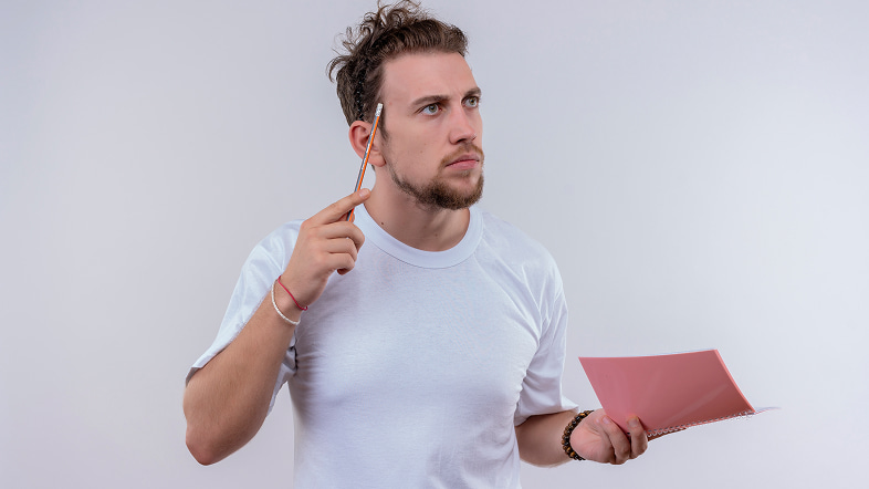 Мужчина обдумывает структуру описания услуги с блокнотом