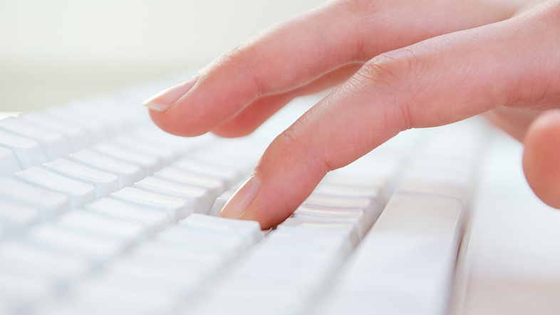 Пальцы руки нажимают белые кнопки на светлой наборной доске