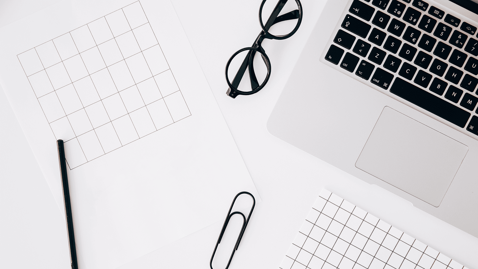 Минималистичное рабочее место с ноутбуком, сетками и канцелярией для презентации идей