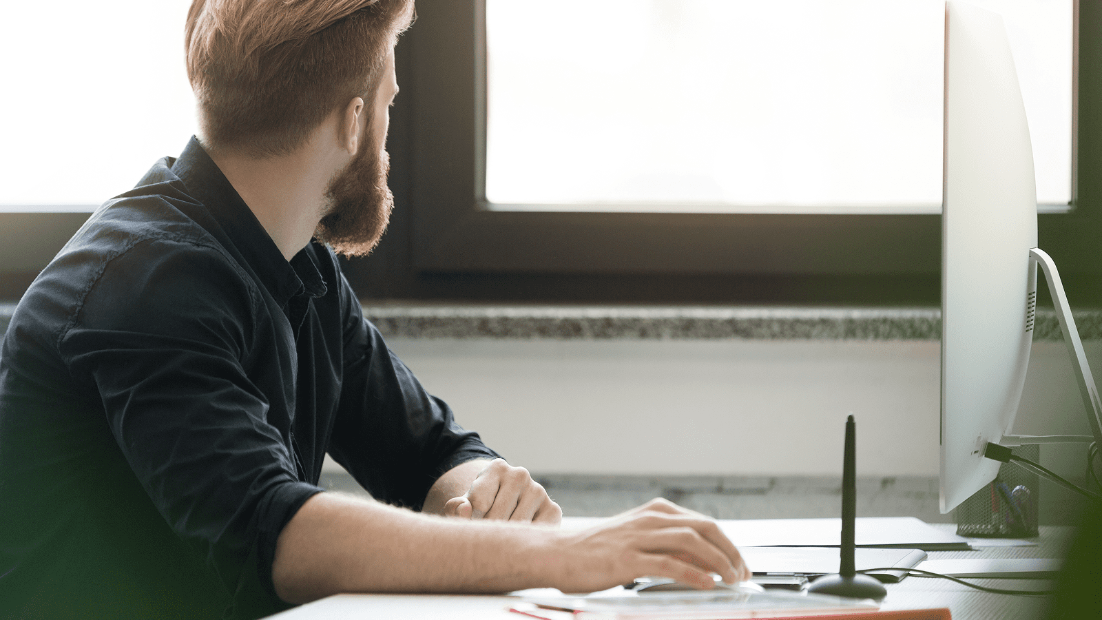 Веб-разработчик за компьютером в офисе, рабочее место с монитором