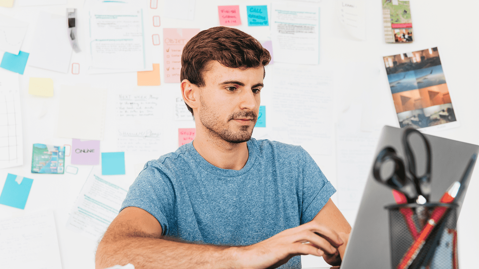 Мужчина за ноутбуком разрабатывает дизайн кнопок призыва к действию в офисе