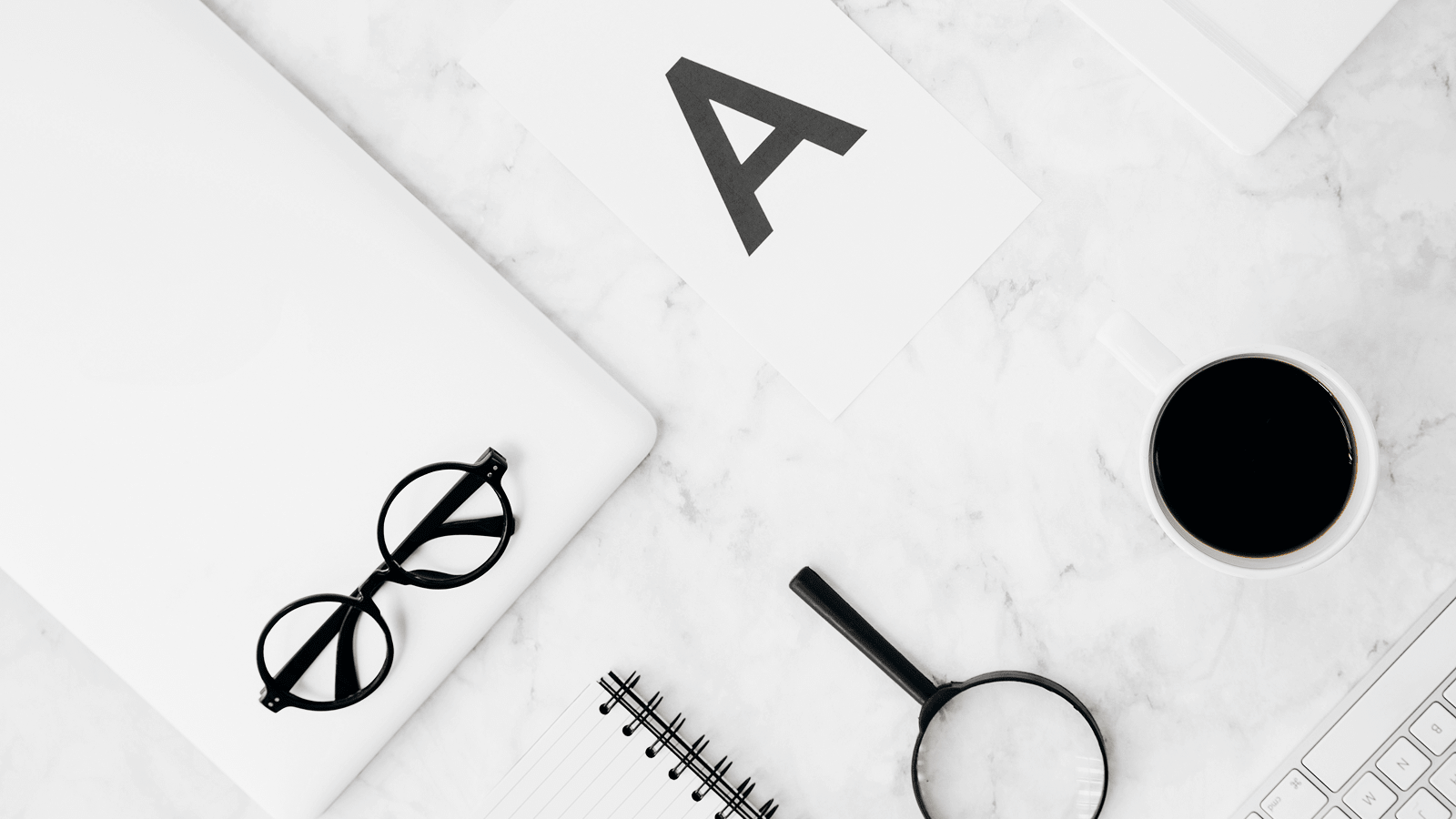 Рабочее место для анализа: ноутбук, лупа, блокнот и кофе