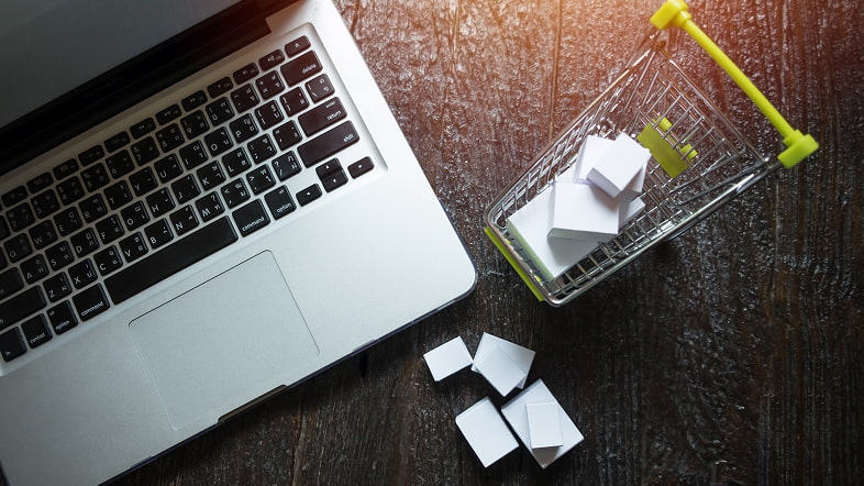 Тележка с коробками рядом с ноутбуком