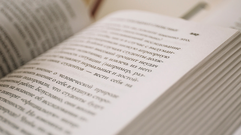 Крупный план раскрытой книги с размытыми страницами и выборочной резкостью