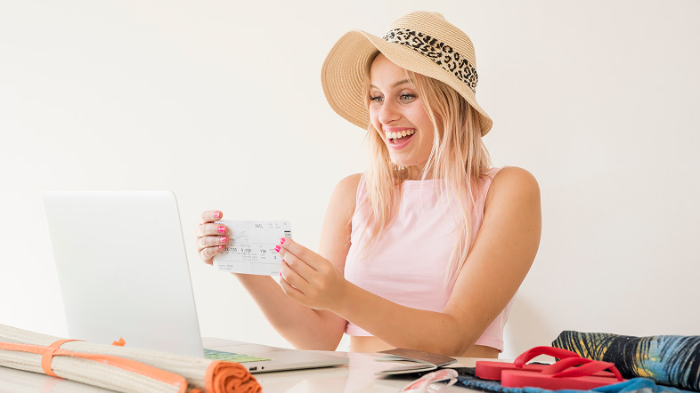 Девушка выбирает поездку дома с дорожными вещами и проездным листком