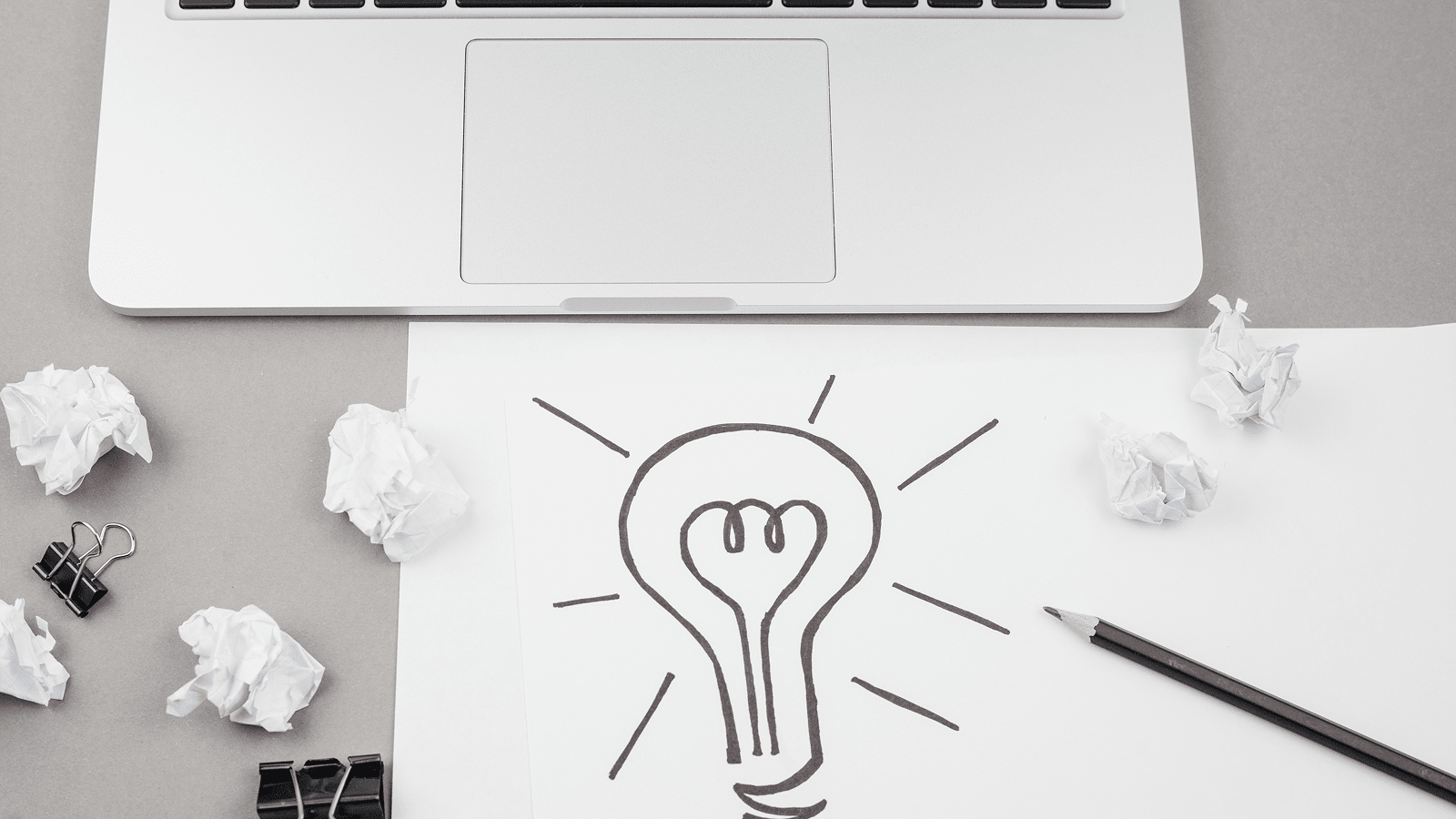 Ноутбук и эскиз лампочки на столе — идея стратегии наполнения содержимым