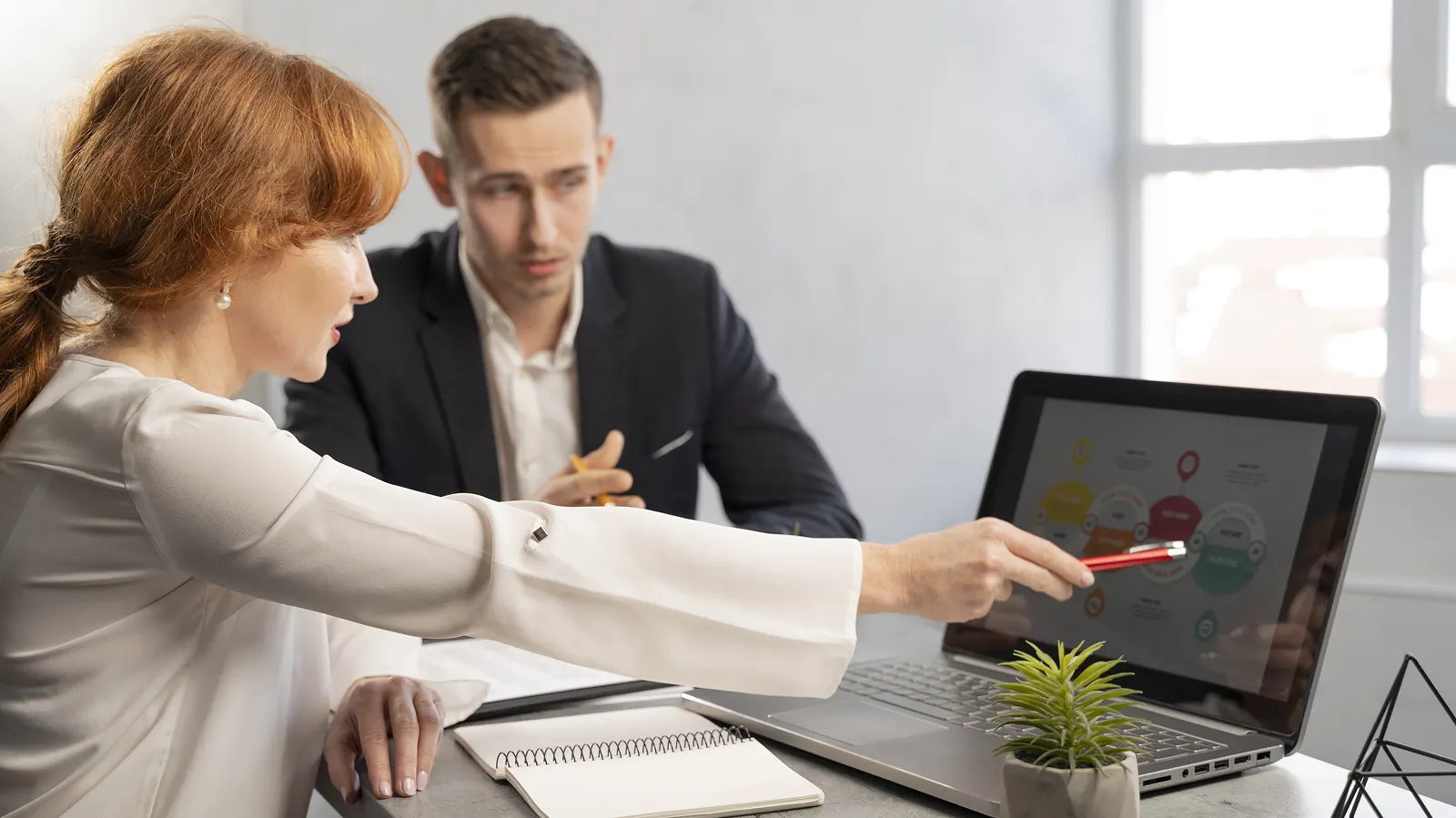 Женщина рассказывает мужчине технические аспекты продвижения сайта